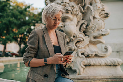 Full length of woman using mobile phone