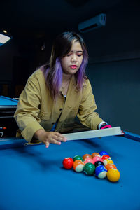 Young woman playing pool