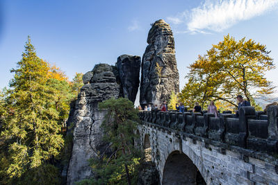 Bridge over rocks against sky