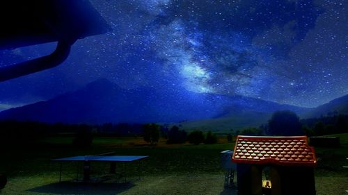 Scenic view of illuminated mountains against sky at night