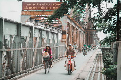 People riding bicycle on street amidst buildings in city