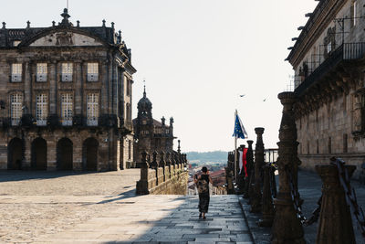 Unidentified woman is walking alone by empty obradoiro square in santiago during pandemic