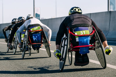 Rear view of man riding bicycle on street