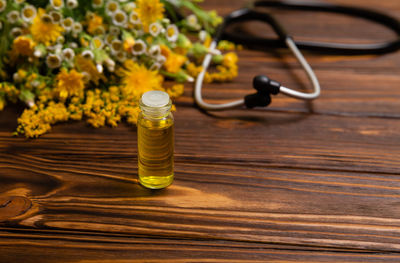 Healing herbs on wooden table. herbal oil in a glass bottle.