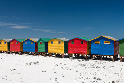 Multi colored beach houses in muizenberg near cape town, south africa against blue sky