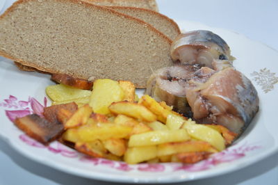 Fried potatoes with fish and bread
