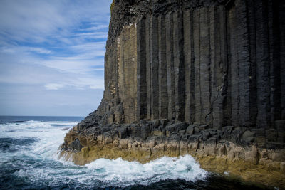 Scenic view of rocks in sea against sky