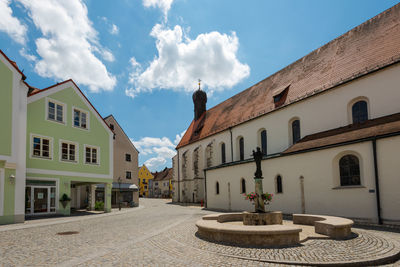 Houses by street in town against sky