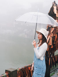 Rear view of woman holding umbrella