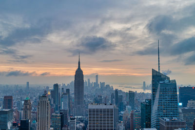 Buildings in city against cloudy sky