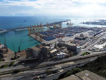 High angle view of commercial dock by sea against sky