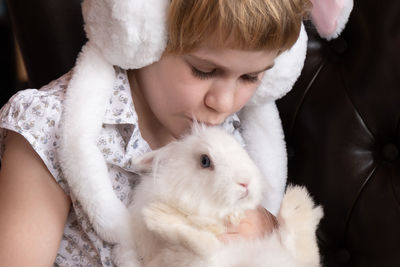 Midsection of girl kissing rabbit