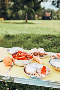 Breakfast prepared during summer vacation on camping. bread, cottage cheese, cold meat, tomatoes