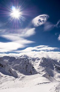 Scenic view of snowcapped mountains against sky on sunny day