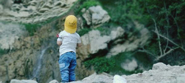 Full length of boy standing on rock