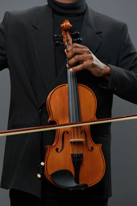 Midsection of man playing violin