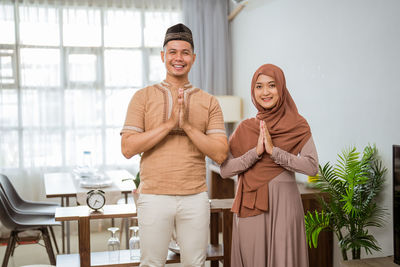 Portrait of smiling couple greeting at home