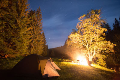 Illuminated tent against sky at night