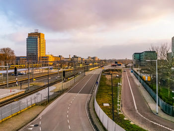 Vehicles on highway in city against sky