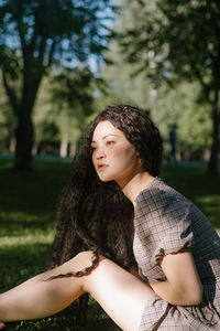 Beautiful young woman sitting in park