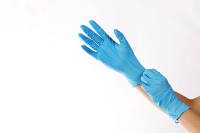 Close-up of hand holding paper over white background