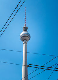 Low angle view of communications tower against blue sky