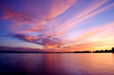 Scenic view of sea against dramatic sky during sunset