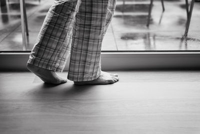 Low section of a barefoot senior woman indoors