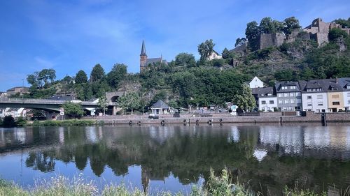 Scenic view of lake by buildings against sky