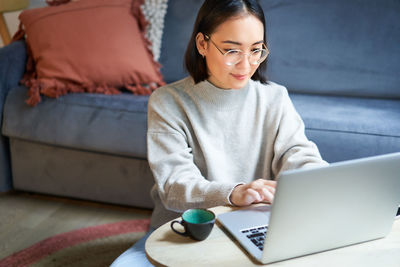 Young woman using laptop at home