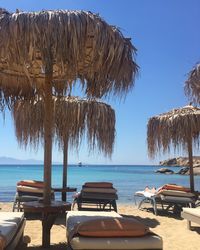 Chairs on beach against clear blue sky