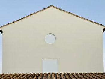 Low angle view of house roof against clear sky