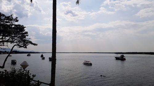 Sailboats in sea against sky