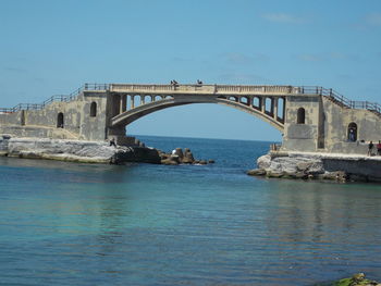 Bridge over water against clear blue sky