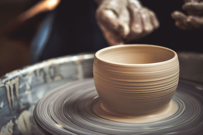 Creating vase of white clay close-up. master crock.the sculptor in the workshop makes a jug 