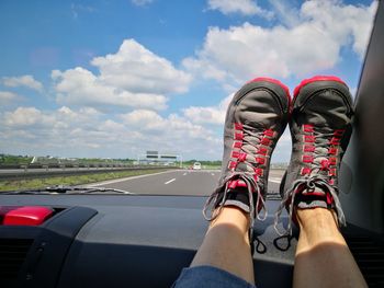 Low section of wearing shoe sitting in car