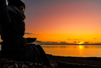 Silhouette man at beach during sunset