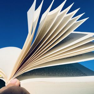 Hand of person reading book on paper