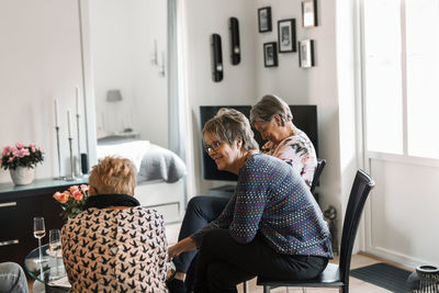 Smiling women talking in living room