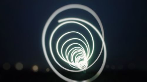 Close-up of illuminated lighting equipment against black background