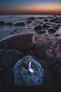 High angle view of rocks at beach during sunset