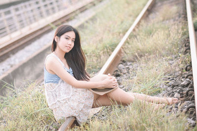 Portrait of young woman sitting on field