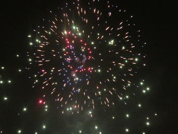 Low angle view of firework display at night