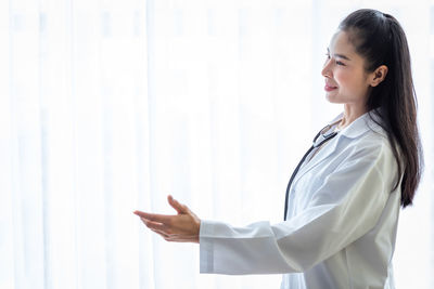 Side view of woman standing at home