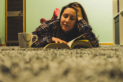 Low angle view of boy on book at home