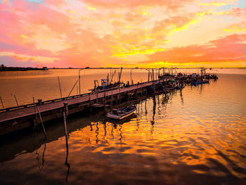 Pier over sea against sky during sunset