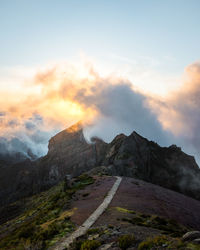 Road by mountain against sky during sunset