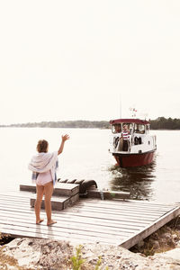 Girl waving to man on ferry