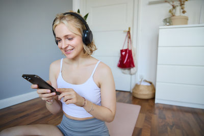 Young woman using mobile phone at home