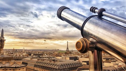 Close-up of coin-operated binoculars against cityscape